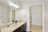The bathroom includes dual sinks, a grantie coutertop, chrome fixtures and plenty of cabinetry for storage!