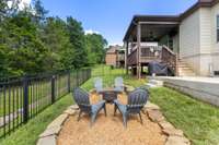 Full view of fenced in back yard with large treeline for privacy.