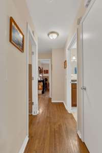 Going down the hallway from the dining area. Natural hardwoods in all 3 bedrooms.