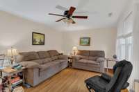 Living Room boast of lots of natural light coming in through large window. And has Ceiling Fan as well as Natural Wood flooring.