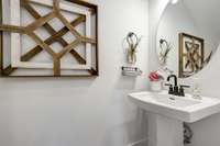 Half bath located on first floor for guests. Photos from previously built Henley.