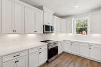 Soft-close cabinets and drawers, dovetail joinery, quartz countertops, upscale kitchen backsplash, under cabinet lighting, upgraded appliances, and even natural light from your window! Actual photo of home.