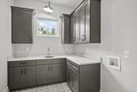 The large laundry room is a sanctuary of efficiency & elegance with cabinets, built in sink, luxurious quartz counter and welcoming window. TO BE BUILT - Buyer can customize ALL selections & options!