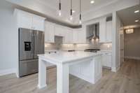 Newly remodeled high end kitchen with wood floors, quartz counter tops, tile back splash, and gas cooktop oven.