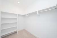 Primary closet with wood shelving