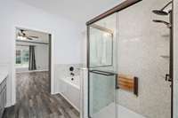 This spacious primary bathroom features a garden tub as well as a newer walk in shower