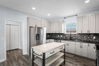 View of kitchen with half bathroom, pantry and laundry room through the open doorway