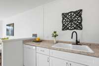 A sleek matte black faucet and new lighting elevate the kitchen’s style.