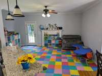 The Gathering Room off the Kitchen and Breakfast Nook - Currently used for a first floor play room for the younger little ones.   Neutral paint and hardwood floors make for an easy transition to meet your desired use.