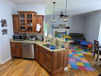 Kitchen work area with kids play room in background