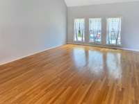 Great Room with sand & finish Oak hardwood floors, soaring ceilings and triple windows to enjoy views of the private back yard! ( PHOTO EDITED to remove furnishings)