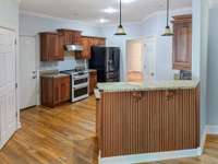 Alternate View of the Kitchen with raised breakfast bar and quality accents.  (PHOTO EDITED to remove misc. personal items)