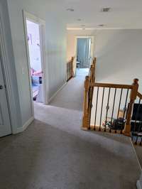 Hallway and Catwalk on the 2nd Floor - Enjoy views to the Great Room and Foyer below.  Neutral Carpet and paint throughout! ( view is from exit of Bedroom #2. Bonus room and a full Bath is located to the LEFT of this picture)