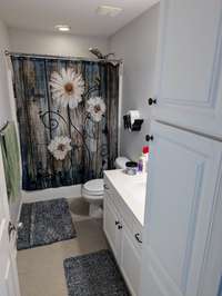 Private Ensuite Bath room in Bedroom #4 with tile floors, spacious vanity and additional cabinetry for ample storage needs.