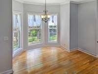 The Lovely Breakfast Nook with Bay window and hardwood floors open to the kitchen and gathering room!  ( PHOTO EDITED to remove personal items )