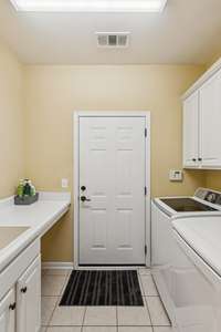 Laundry room with sink. Several cabinets for storage. Washer and dryer included.
