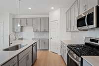 Check out the spacious kitchen with the optional upgraded tall cabinets.  Quartz countertops, tile backsplash, and stainless appliances with gas stove included.  Colors and selections may vary