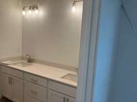 Dual sink vanity with quartz countertops in Owners bathroom