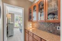 A butler's pantry/ bar area connects the kitchen to the formal dining room, allowing for easy entertainment and extra storage for glassware and china.