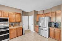 The laundry room (left door) and garage (right door) are conveniently located near the kitchen.  *Refrigerator in this photo does not remain*