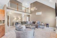 A spacious, two-story living room anchors the home between the primary suite and the kitchen.
