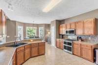 All appliances are stainless steel, including a double convection oven, built-in microwave, and dishwasher.