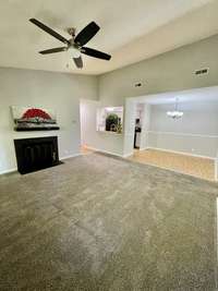Spacious Living Room w/ Vaulted Ceiling and wood burning Fireplace.  Note: Freshly painted in Sherwin Williams "Mindful Gray".