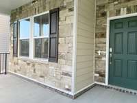 This home features a beautiful stone exterior design with black iron railing along the extended Covered Porch.