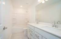 Bath #2 is located on the 2nd floor and offers tile flooring and dual sinks with quartz countertops.