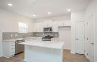 Quartz countertops and a modern 2" x 6" subway tile backsplash are also included in the Kitchen.