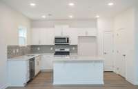 The Kitchen includes white cabinetry with soft-close doors, roll out trays and built-in recycling and garbage bins!