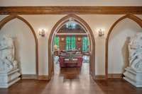 The hallway is wide and long with lined on both sides with a sequence of pointed Gothic arches. One side is the library and the other side is the Great room.