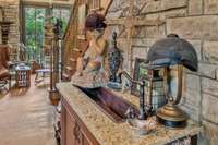 @nd sink in kitchen against stone wall