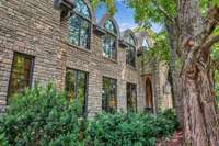The cathedral-style windows echo a style right out of Hogwarts. Majestic old trees surround the home which frames the property with natural elegance and offers a sense of history and grounding