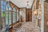 marble surrounded in arches as you bath and look. A sunken bath is the epitome of romantic luxury. Arched windows frame views of the privacy from the foliage allowing soft natural light to pour in while maintaining a sense of seclusion