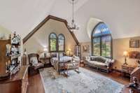 This bedroom is a dramatic calming retreat with soaring ceilings and arched windows