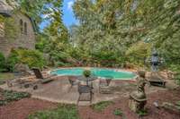 Tucked behind the towering stone walls of this estate the pool of this home feels like a hidden sanctuary framed by aged stone walls and mature trees that can tell stories with their age, shape, scars and setting.