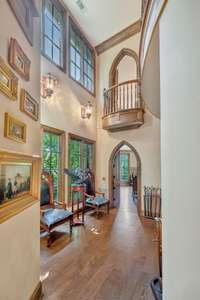A gracefully curved hallway with a gallery style art wall leads you to the dining room set in a turret