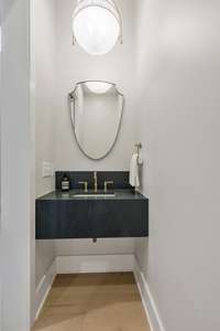 Powder Bathroom with Floating Quartz Vanity Located off the Entry Hall