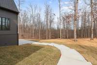 Driveway Connects to Backyard with Walkway Down to Patio