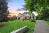 Arrive in style along a private drive bordered by sculpted gardens and vibrant greenery, offering both beauty and privacy in this exclusive neighborhood.
