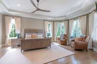 Spacious primary bedroom with tray ceiling, sitting area, and abundant windows with loads of natural light.