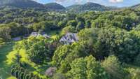 Breathtaking aerial perspective showcasing the property’s lush landscape, privacy, and stunning hillside surroundings.