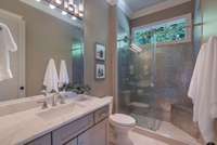 Modern full bathroom featuring a large vanity, stylish lighting, and a glass-enclosed shower.  bathroom 2.