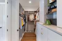 Impressive walk-in closet with built-in shelving, abundant hanging space, and custom cabinetry