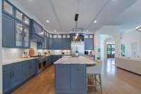 Large central island with seating, surrounded by abundant cabinetry and premium appliances.