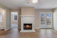 Wood buring FP in Den with luxury vinyl plank flooring throughout primary living areas.