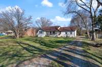 Driveway extends around back of the home to attached 2 car garage and detached 2 car garage/workshop.