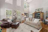 Great Room With Soaring Ceiling And Lots Of Windows Providing Able Amount Of Natural Light