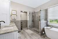 Remodeled Primary Bathroom With New Vanity, Granite Counters And Tile Flooring